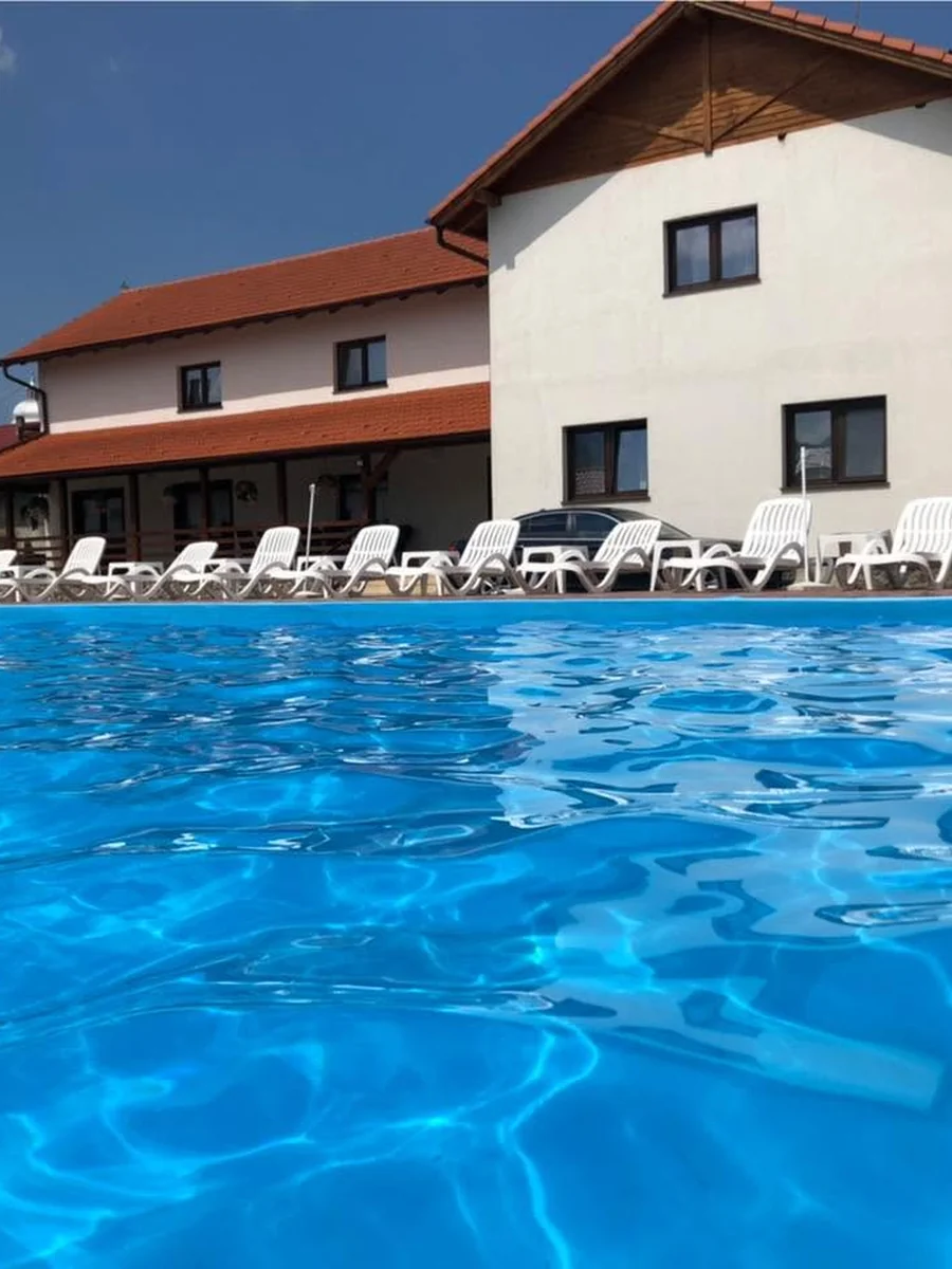Pensiunea Ony și piscina exterioară într-o zi senină